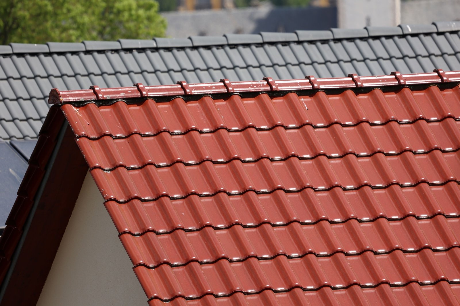 Closeup of a typical tiled roof and chimney against blue sky